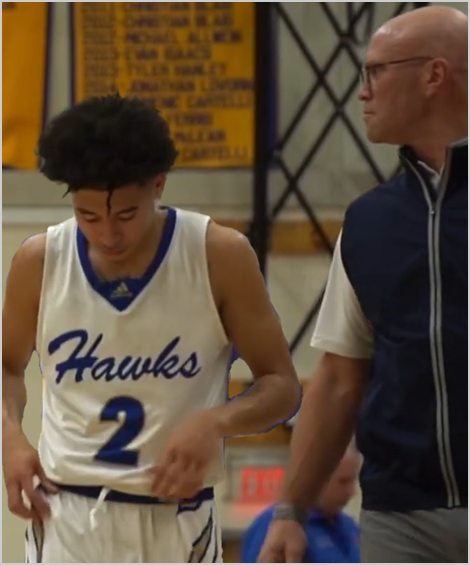 In game action, Makai passes Coach Goldshore on the sideline.